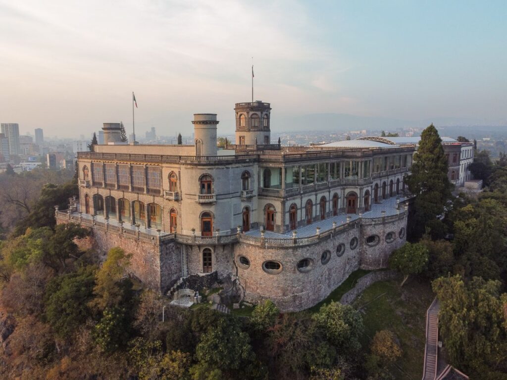 Stunning aerial view of Chapultepec Castle perched on a hill in Mexico City at sunset.